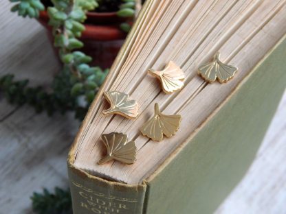 mini gold ginkgo pins balanced on a book